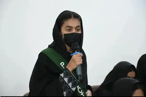 A student speaking into a microphone during a school programme