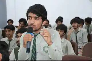 A student speaking into a microphone during a school programme